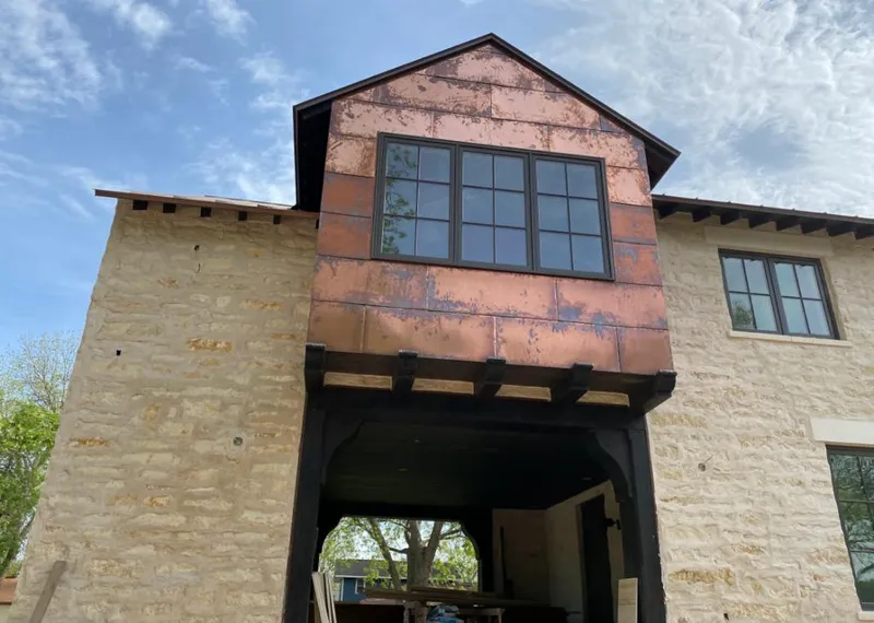 Copper metal panel facade on a stone building for Skylight Installation in Great Bend